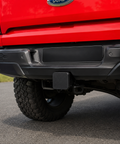 Rear view of a red Next Gen Ford Ranger with the tow receiver cover fitted to the tow bar